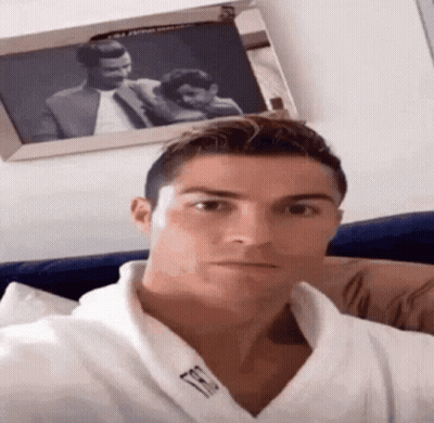 Man In White Robe Taking Selfie With Framed Couple GIF