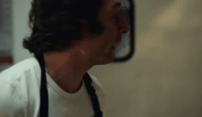Man In White Shirt And Apron In Front Of Mirror GIF