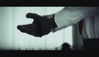 Man In White Shirt And Black Gloves Reaching GIF