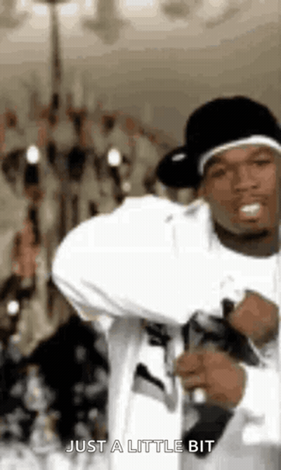 Man In White Shirt And Black Hat Holding Microphone Saying Just A Little Bit GIF