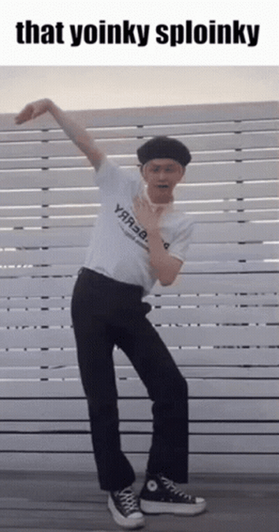 Man In White Shirt And Black Pants Dancing In Front Of Fence Saying That Yoinky Sploinky GIF