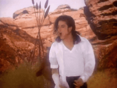 Man in White Shirt and Black Pants Standing in Desert