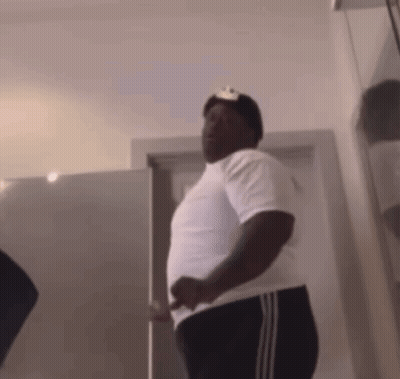 Man In White Shirt And Black Pants Standing In Front Of Door GIF