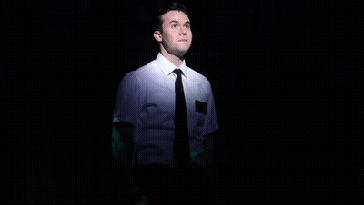 Man in White Shirt and Black Tie on Stage With Mickey