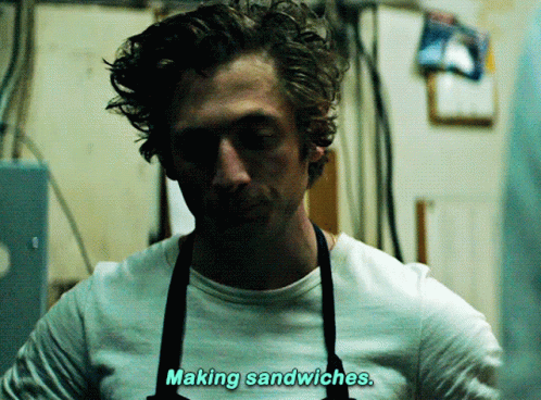 Man in White Shirt and Blue Apron Looking at Camera