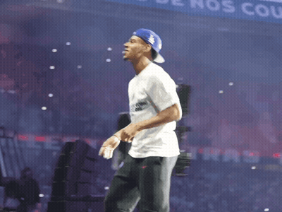 Man In White Shirt And Blue Hat Before Banner Saying Nos Coule GIF