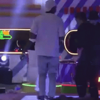 Man In White Shirt And Blue Jeans On Stage With People GIF