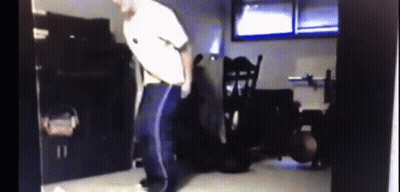 Man In White Shirt And Blue Pants Dancing In Dark Room GIF