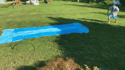 Man In White Shirt And Blue Shorts On Water Slide GIF
