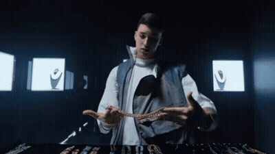 Man In White Shirt And Blue Vest Holding Chain GIF