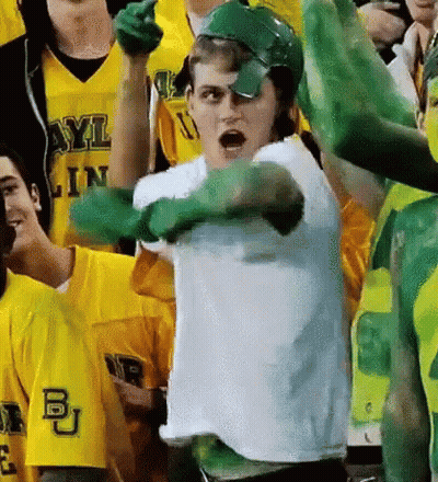 Man In White Shirt And Green Gloves Standing Before Crowd GIF