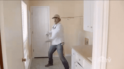 Man In White Shirt And Hat Standing In Room GIF