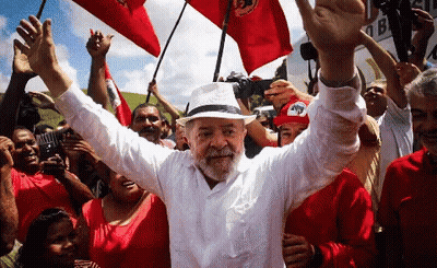 Man In White Shirt And Hat Surrounded By People GIF
