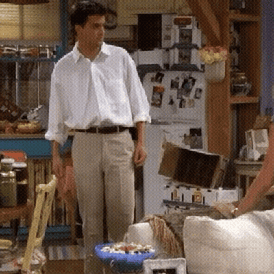 Man In White Shirt And Khaki Pants By Refrigerator GIF