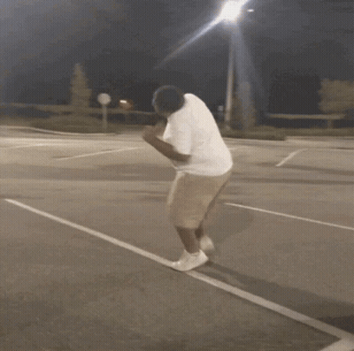 Man In White Shirt And Khaki Shorts Running On Parking Lot GIF