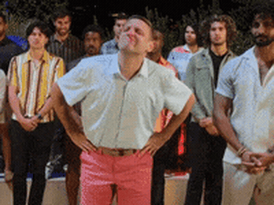 Man In White Shirt And Pink Pants Standing Before Group GIF