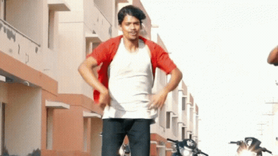 Man In White Shirt And Red Jacket Standing In Front Of Building GIF
