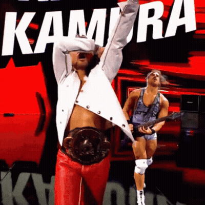 Man In White Shirt And Red Pants In Front Of Kamira Sign GIF