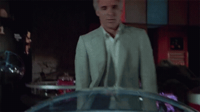 Man In White Shirt And Suit Looking In Dark Room GIF
