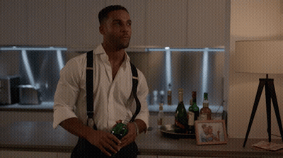 Man In White Shirt And Suspenders Holding Bottle GIF