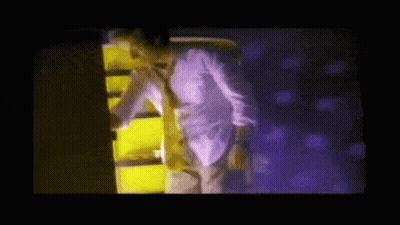 Man In White Shirt And Tie In Front Of Purple Wall GIF