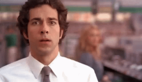 Man In White Shirt And Tie Looking At Camera In Store GIF