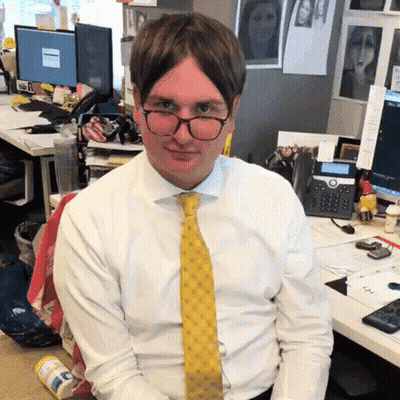 Man In White Shirt And Yellow Tie Sitting At Desk GIF