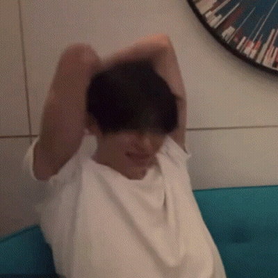 Man In White Shirt Arms Outstretched On Blue Couch GIF
