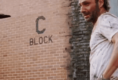 Man In White Shirt At Brick Wall With Block GIF