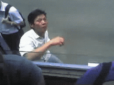 Man In White Shirt At Table In Crowd GIF