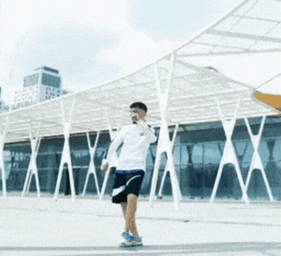Man In White Shirt Blue Shorts Under Umbrella GIF