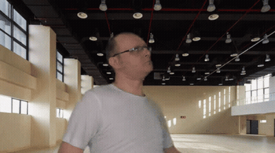 Man In White Shirt By Red Exit Sign GIF