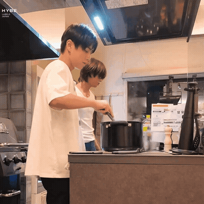 Man In White Shirt Cooking With Japan Ceiling Label GIF