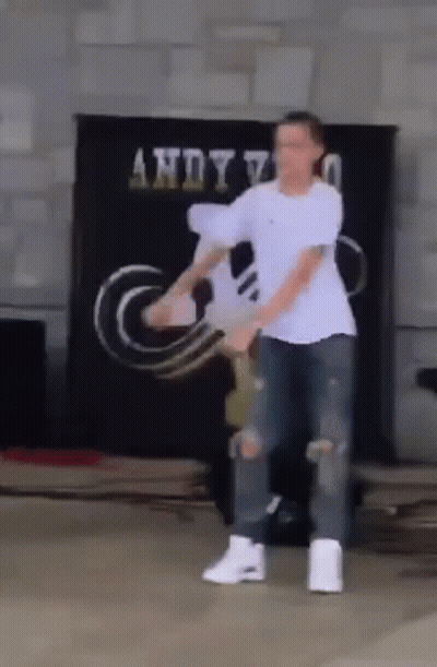 Man In White Shirt Dancing In Front Of Andy Sign GIF