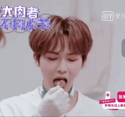 Man In White Shirt Eating Food In Front Of Ioiyi Ad GIF