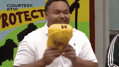 Man In White Shirt Eating Yellow Object With Letter W GIF