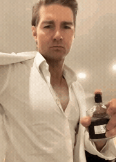 Man In White Shirt Holding Bottle Of Perfume GIF