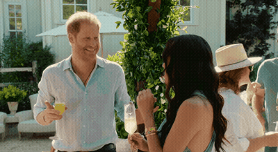 Man In White Shirt Holding Champagne Talking To Woman GIF