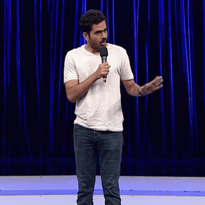 Man In White Shirt Holding Microphone Making Funny Face GIF