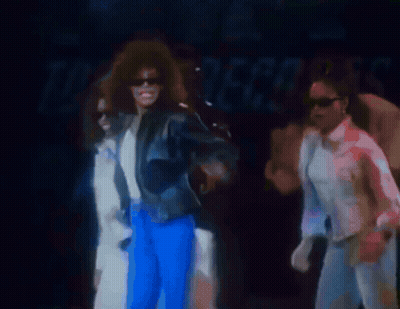 Man In White Shirt Holding Microphone On Stage GIF