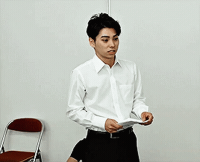Man In White Shirt Holding Paper Near Chair GIF