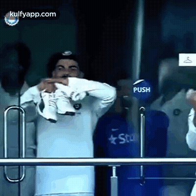 Man In White Shirt Holding Shoes GIF