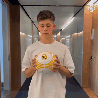 Man In White Shirt Holding Soccer Ball Hallway GIF