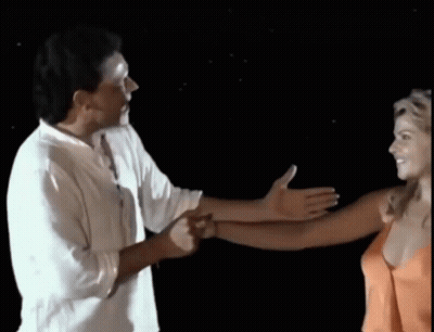 Man In White Shirt Holding Woman In Orange Top GIF
