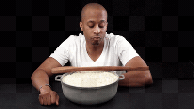 Man In White Shirt Holding Wooden Spoon Over Rice Bowl GIF