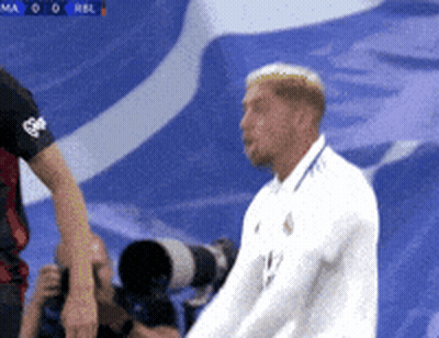 Man In White Shirt In Front Of Blue Background GIF