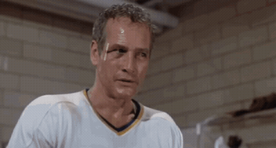 Man In White Shirt In Front Of Brick Wall Saying Okay GIF