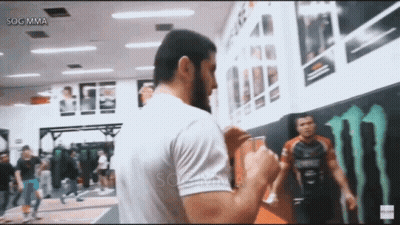 Man In White Shirt In Front Of Monster Energy Logo GIF