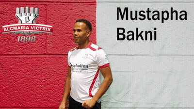 Man In White Shirt In Front Of Mustapha Bakni Wall GIF
