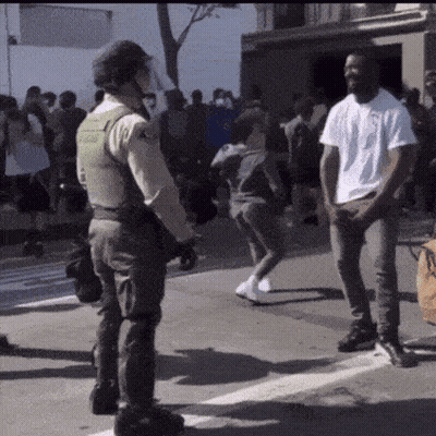 Man In White Shirt In Front Of Police Officer GIF